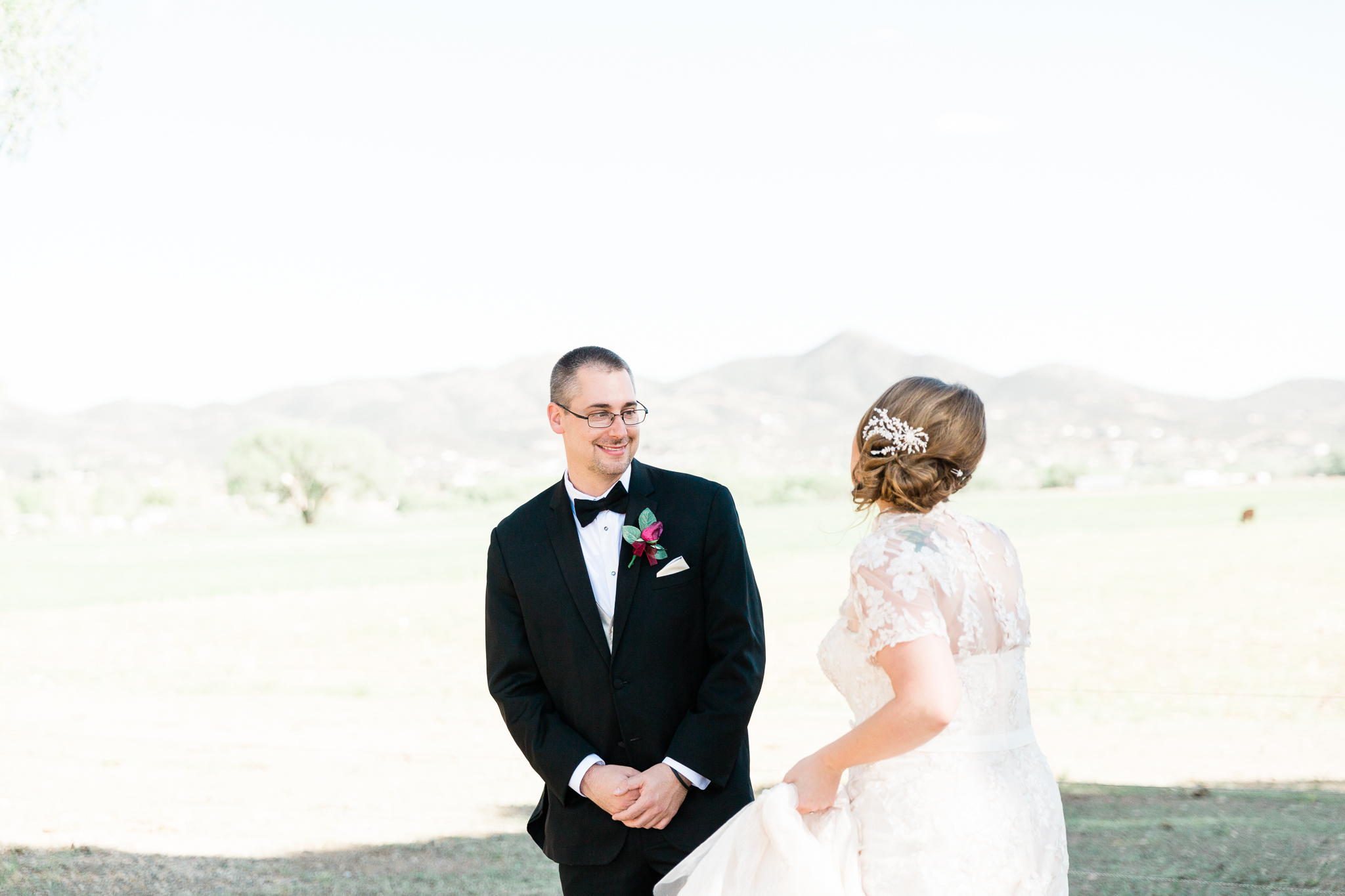 The groom in the black tux has turned around to see his bride in her ivory gown. He has a smile on his face, and her body language is elated. Location is Mortimer Farms, Prescott, Arizona