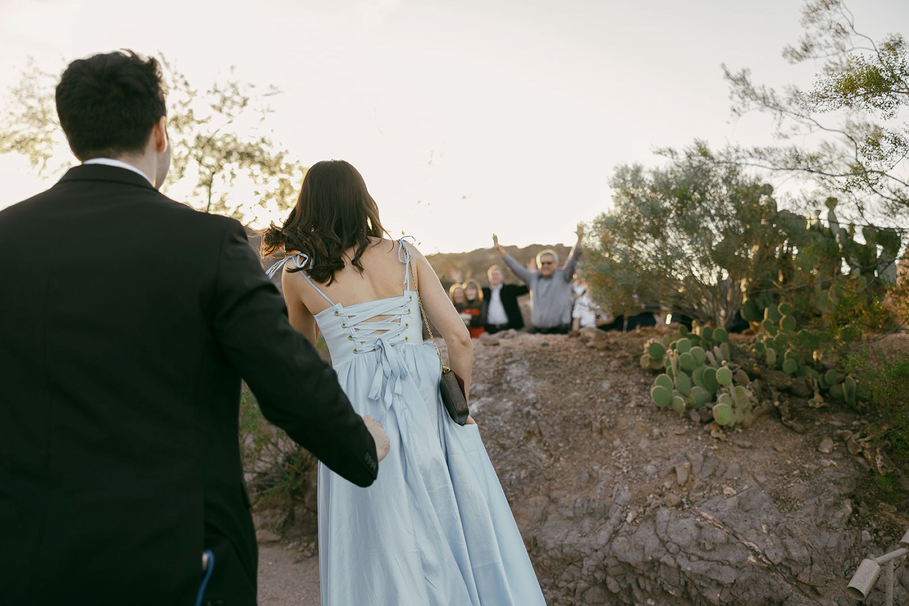 A couple walking towards their family who is celebrating their engagement 