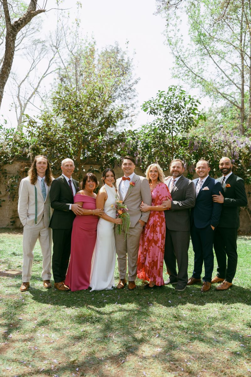 a couple with their invited guests at their wedding standing next to them