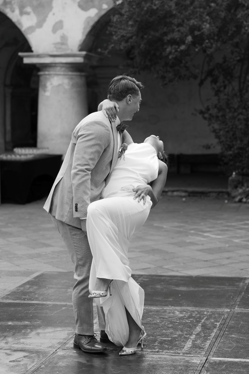 a man and woman on the dance floor the man is dipping his partner backwards
